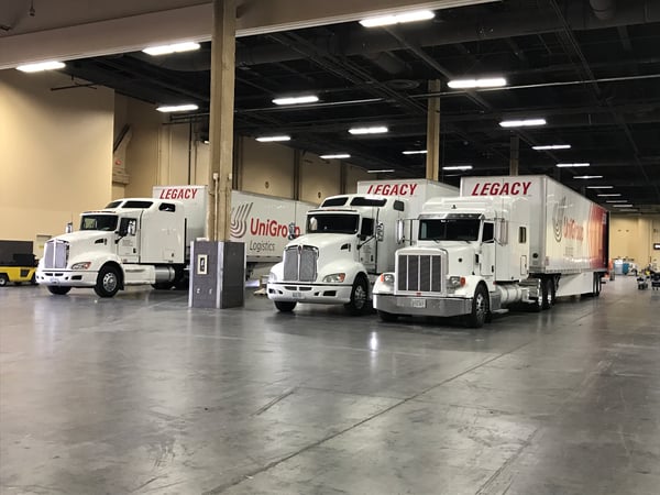 Legacy trucks staged inside a convention center, supporting coordinated trade show exhibit shipping and on-time delivery to the show floor