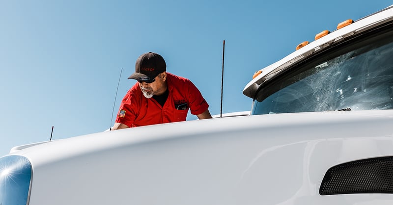 Legacy truck driver working on the hood of the truck