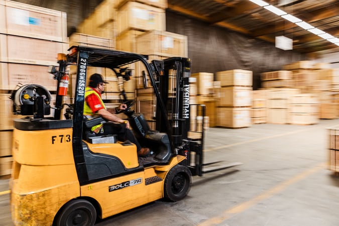 Warehouse worker operating a forklift in a Legacy logistics facility.