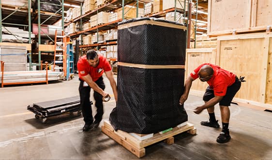 Legacy team members securing shipment to pallet