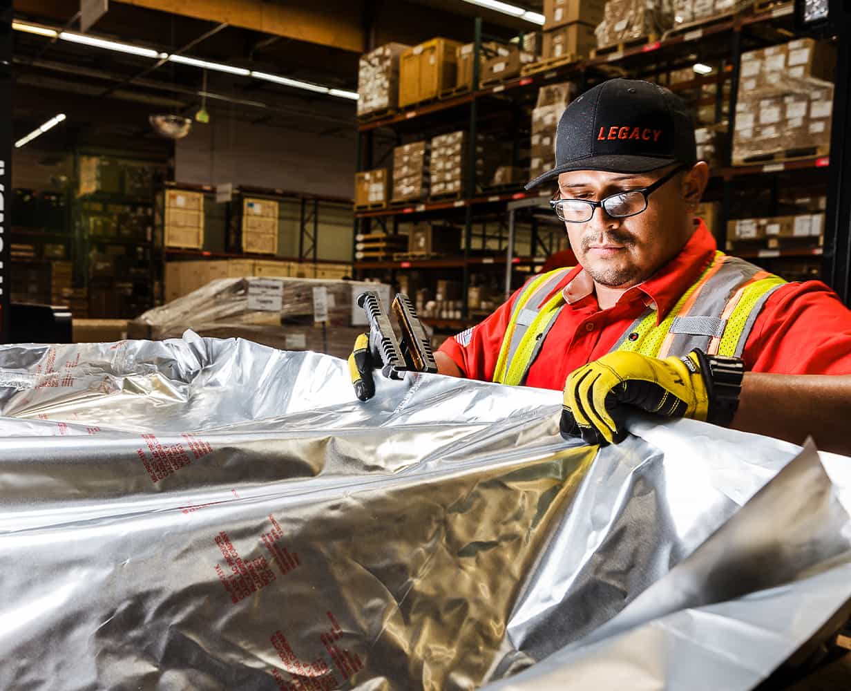 Legacy team member adjusting cover over specialized cargo