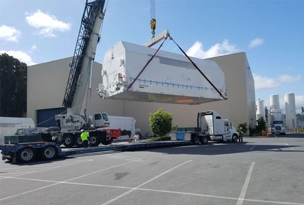 oversized cargo being placed onto flatbed truck