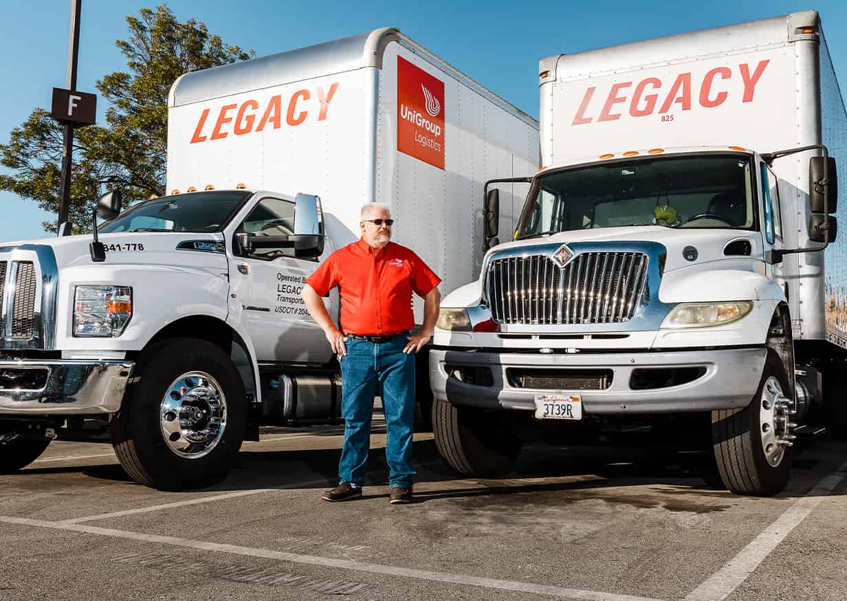 team member standing in front of straight trucks