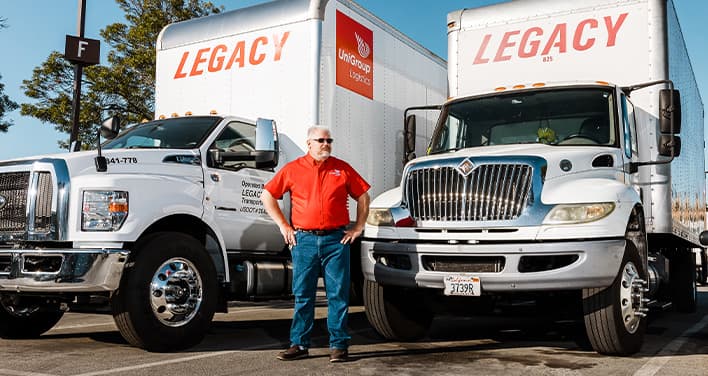 team member standing in front of straight trucks