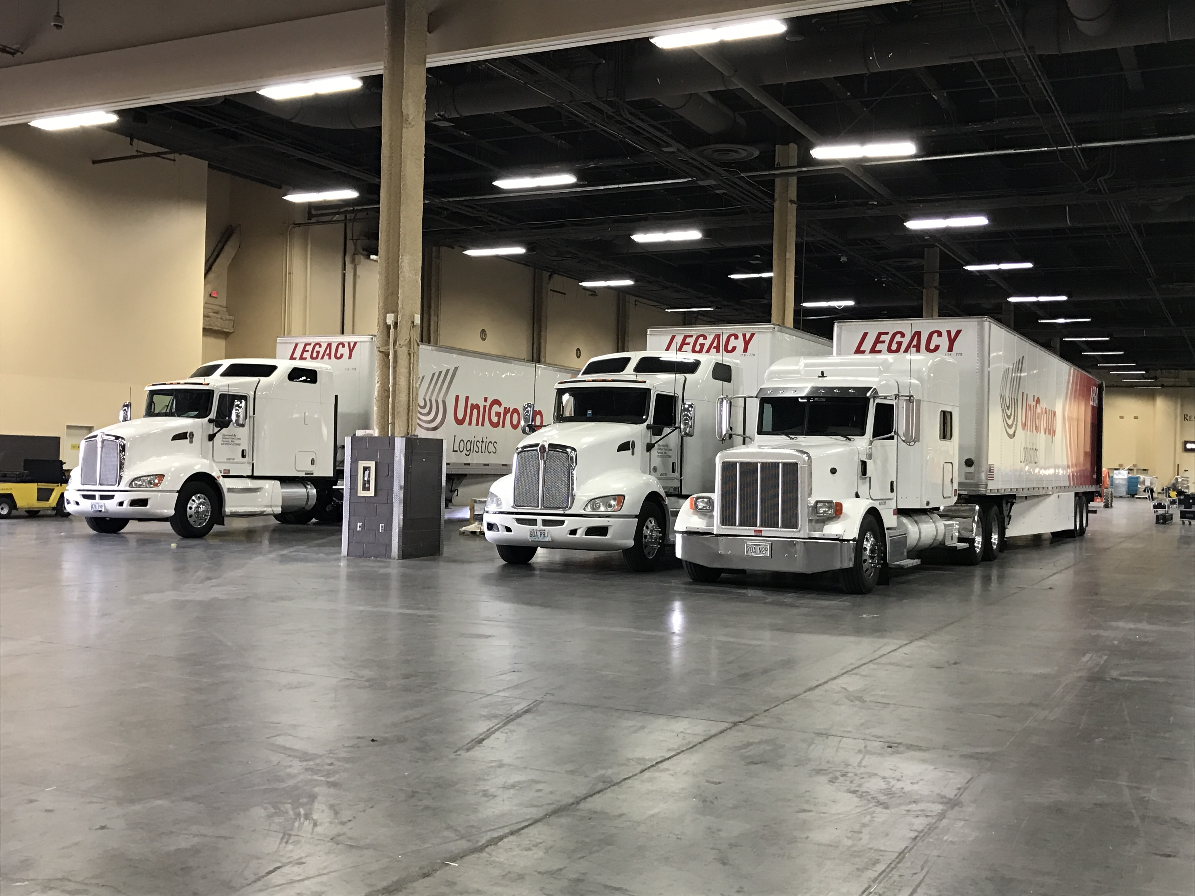 Legacy trucks staged inside a convention center, supporting coordinated trade show exhibit shipping and on-time delivery to the show floor