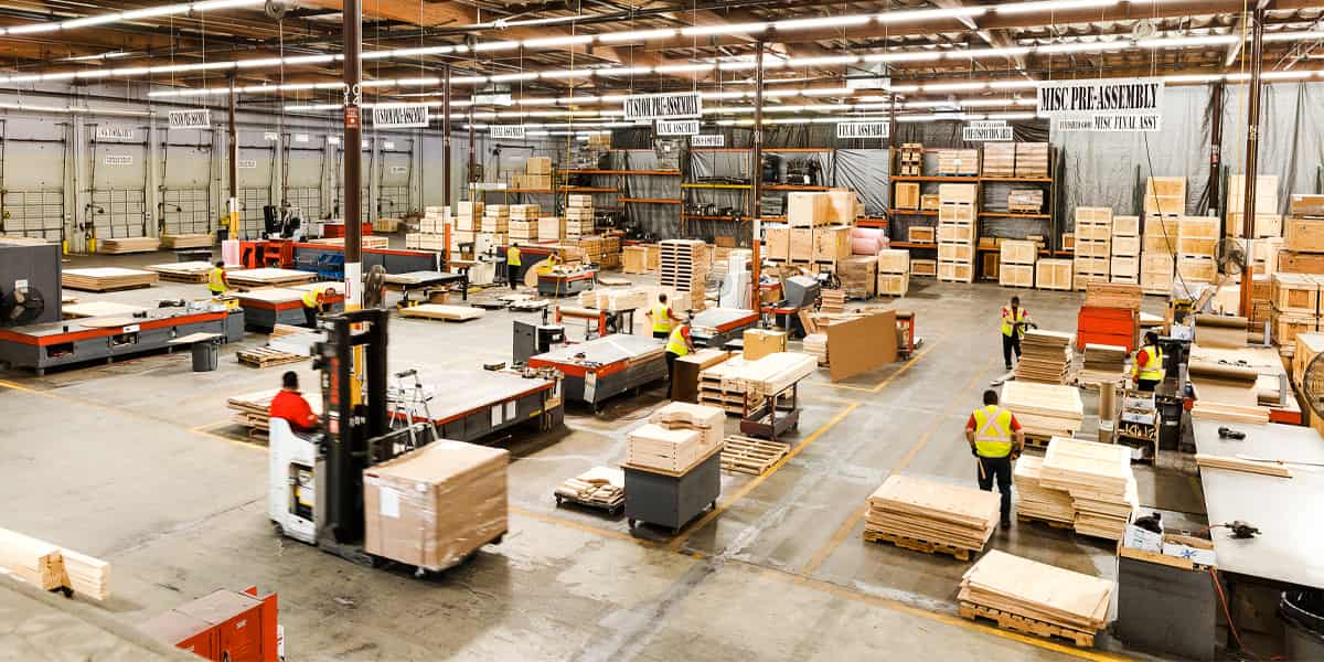 Workers coordinate freight packaging in a logistics facility.